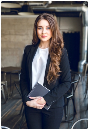 brunette-business-woman-with-wavy-long-hair-blue-eyes-stands-holding-notebook-hands